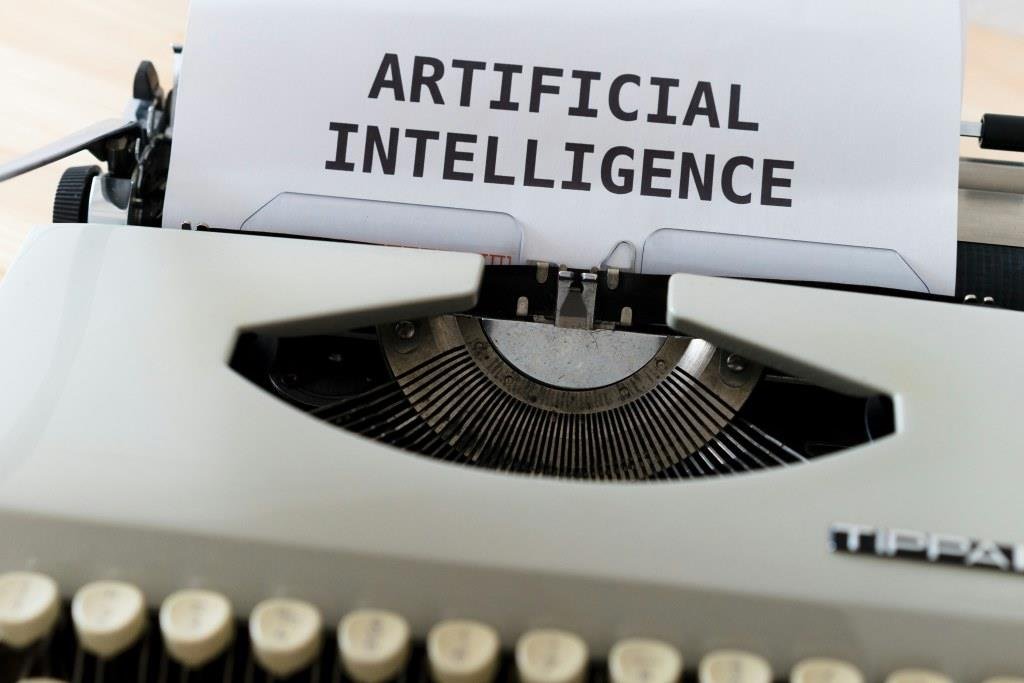 Imagen de una máquina de escribir analógica, con un papel donde está escrito inteligencia artificial para ilustrar el post de Foro Géiser sobre el futuro de la IA